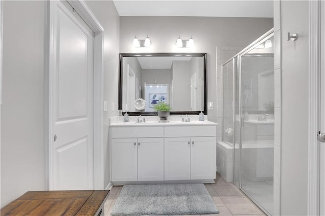 bathroom with double vanity, tile patterned flooring, a shower stall, and a sink