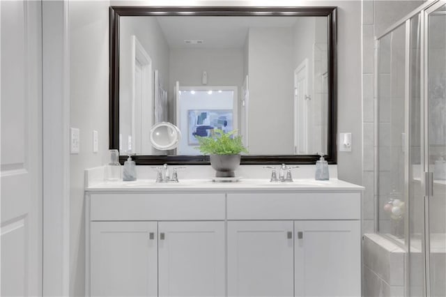 bathroom featuring a sink, visible vents, a stall shower, and double vanity