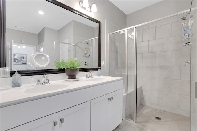 full bath with double vanity, a stall shower, and a sink