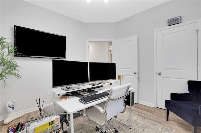 home office with baseboards and light wood-style floors