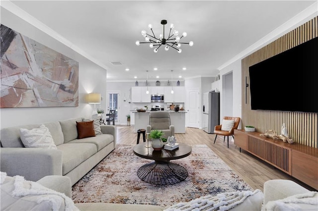 living room with recessed lighting, light wood-style flooring, a chandelier, and ornamental molding