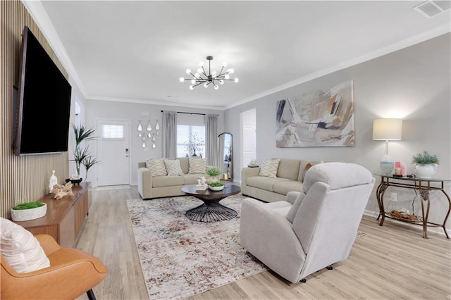 living area featuring visible vents, an inviting chandelier, ornamental molding, and light wood finished floors