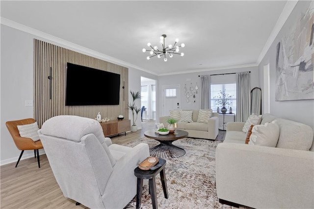 living area with light wood finished floors, baseboards, crown molding, and an inviting chandelier