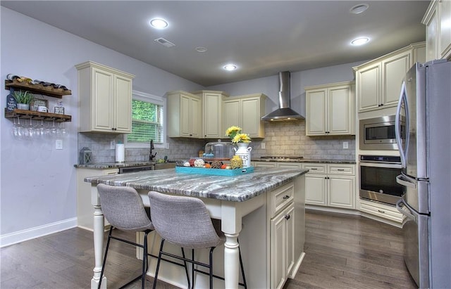 116 Chorley Run, Ellenwood, GA 30294 - kitchen with appliances with stainless steel finishes, wall chimney range hood, cream cabinetry, backsplash, and light stone counters