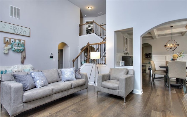 116 Chorley Run, Ellenwood, GA 30294 - living room with stairway, beamed ceiling, arched walkways, dark wood-style floors, and a chandelier