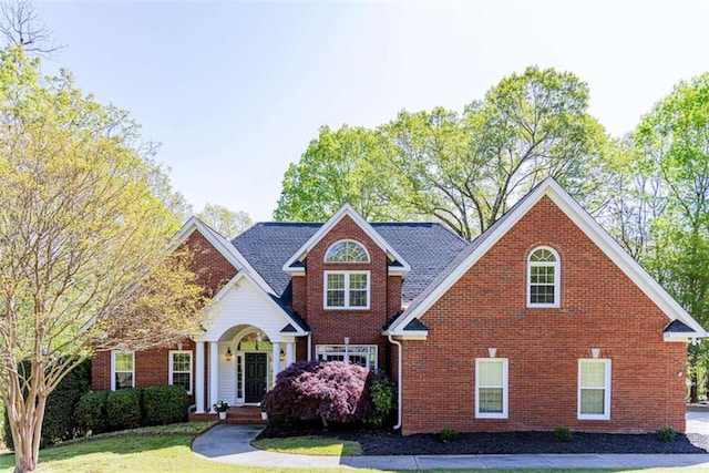 view of front of house with brick siding and a front yard
