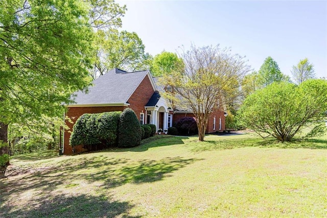 view of front of home with a front lawn and brick siding