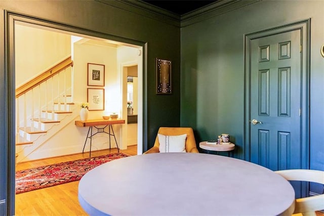 bedroom with baseboards, crown molding, and wood finished floors