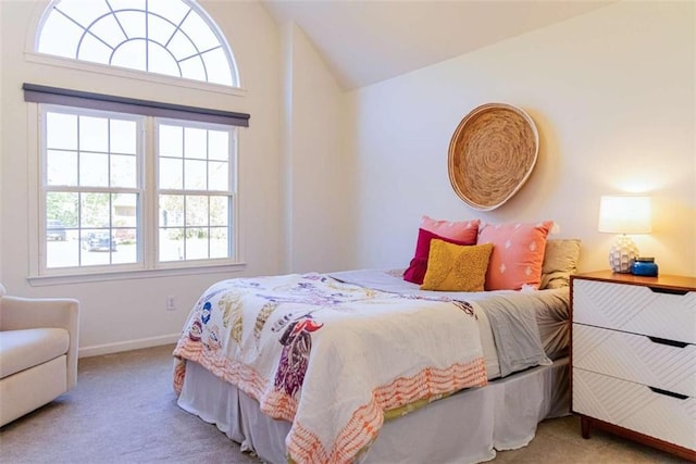 bedroom featuring multiple windows, carpet flooring, and lofted ceiling