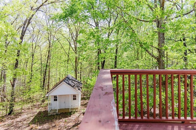 view of community with a wooded view and an outdoor structure