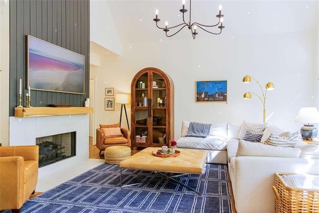 living area with a large fireplace, a high ceiling, arched walkways, and a chandelier