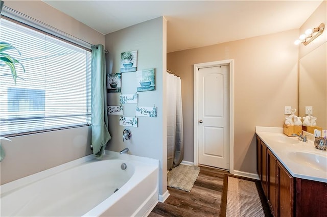 1574 Leonard St, Hampton, GA 30228 - bathroom with wood finished floors, a garden tub, double vanity, and a shower with shower curtain