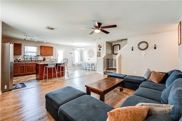 1574 Leonard St, Hampton, GA 30228 - living area featuring ceiling fan, light wood finished floors, a chandelier, and stairway