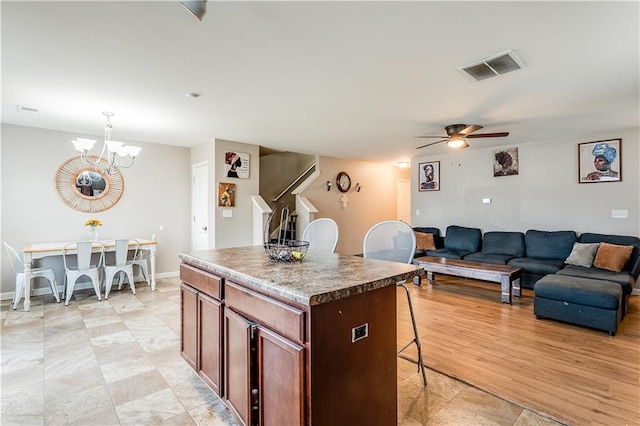 1574 Leonard St, Hampton, GA 30228 - kitchen featuring a breakfast bar area, a kitchen island, ceiling fan, a chandelier, and open floor plan