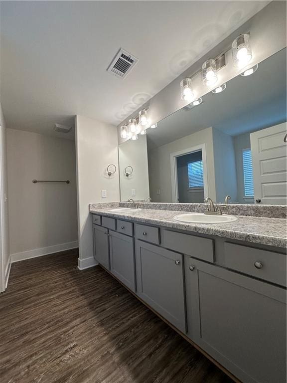 bathroom with visible vents, wood finished floors, baseboards, and a sink