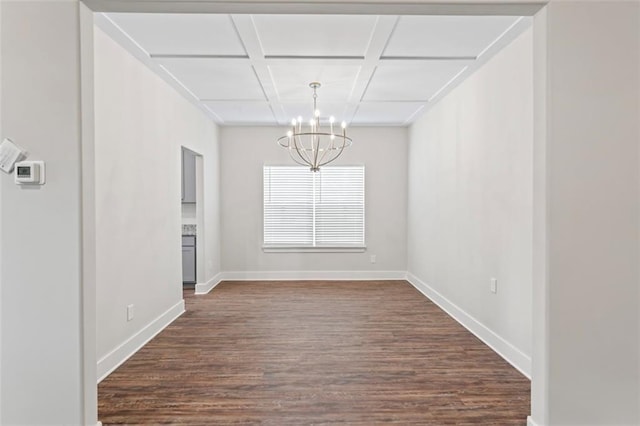 unfurnished dining area featuring baseboards, coffered ceiling, a chandelier, and dark wood-style floors
