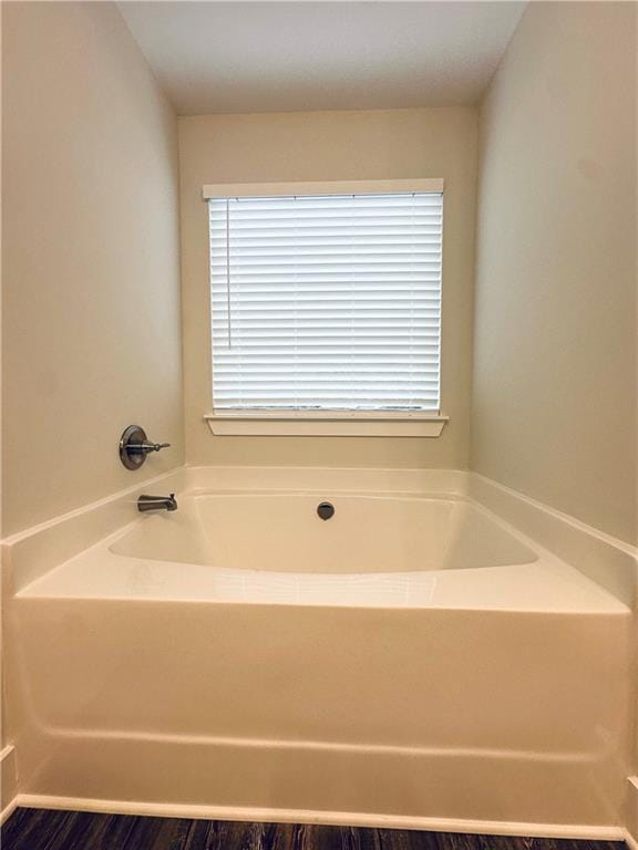 full bathroom featuring a garden tub and a healthy amount of sunlight