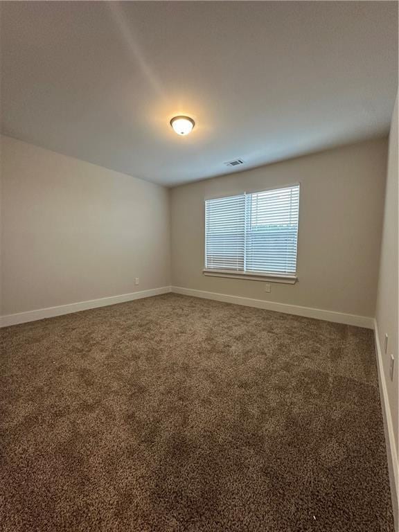 carpeted empty room featuring visible vents and baseboards