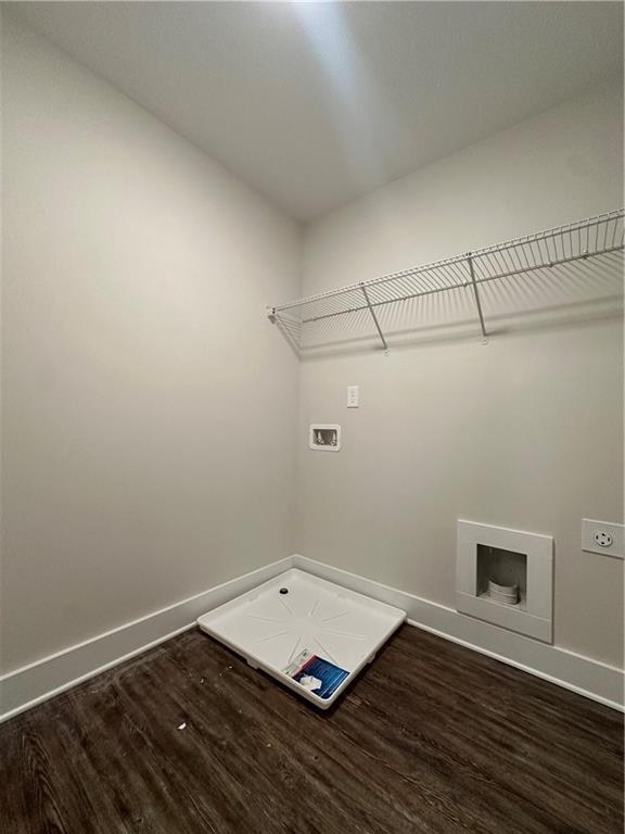 laundry area featuring dark wood finished floors, laundry area, baseboards, and washer hookup