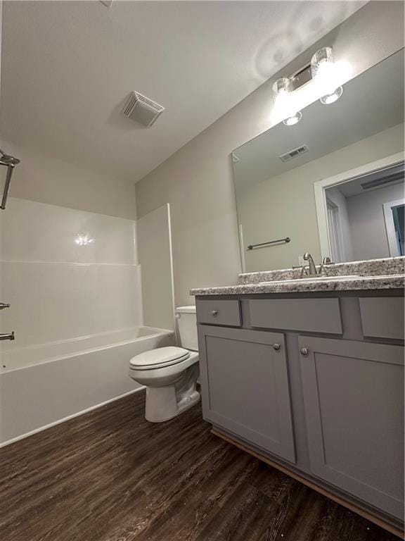 full bath with visible vents, toilet, and wood finished floors