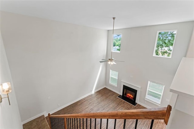 unfurnished living room featuring baseboards, a fireplace with flush hearth, and a wealth of natural light