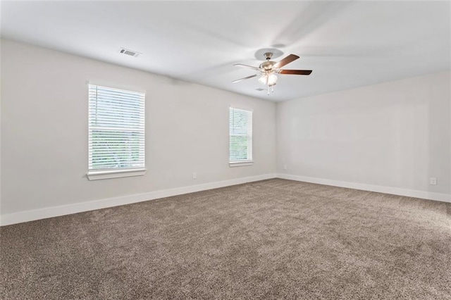 unfurnished room with carpet floors, baseboards, ceiling fan, and visible vents