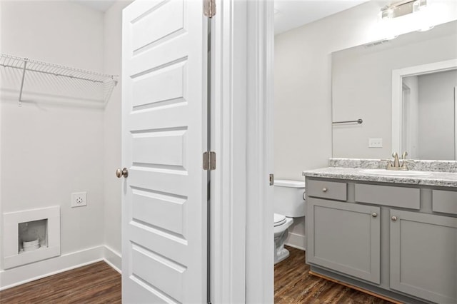 bathroom with vanity, baseboards, toilet, and wood finished floors