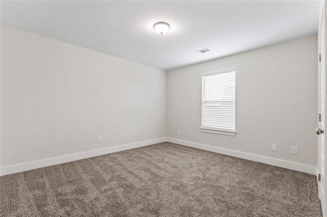 carpeted spare room featuring baseboards and visible vents