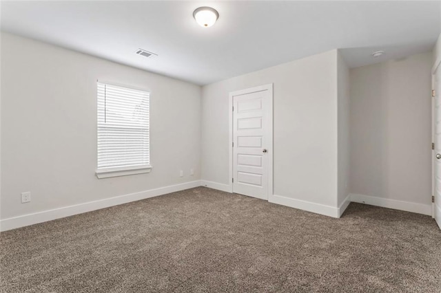 carpeted spare room with baseboards and visible vents