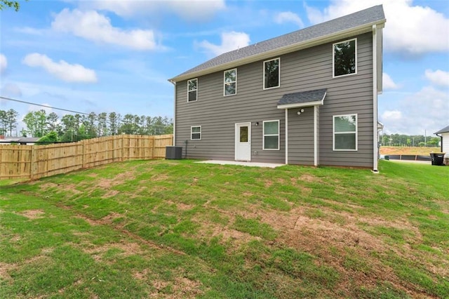 rear view of house with central AC unit, a patio area, fence, and a yard