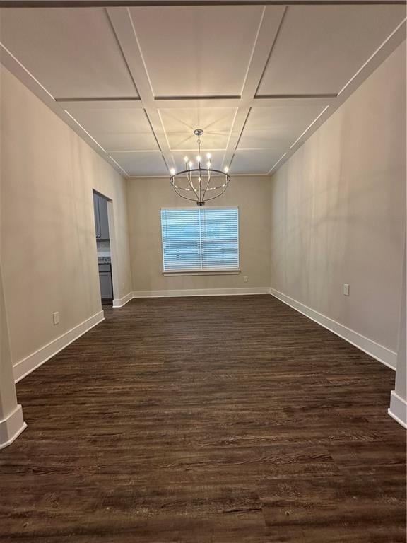 empty room featuring baseboards, dark wood-style flooring, coffered ceiling, and a chandelier