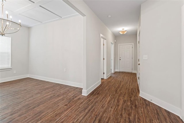 hallway with an inviting chandelier, baseboards, and dark wood-style floors