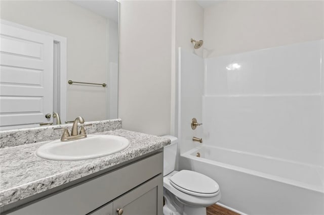 full bath featuring toilet, shower / bath combination, wood finished floors, and vanity