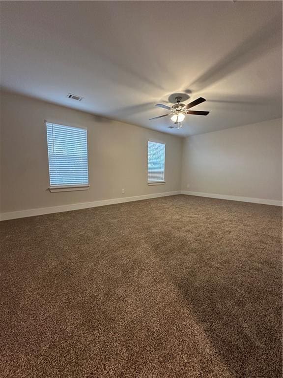 unfurnished room with visible vents, baseboards, and carpet