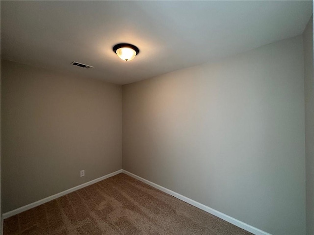 spare room featuring visible vents, carpet flooring, and baseboards