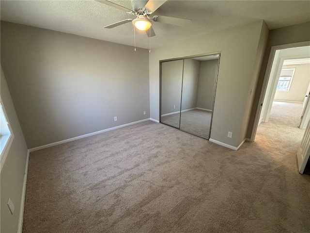 unfurnished bedroom with a closet, baseboards, a textured ceiling, and carpet