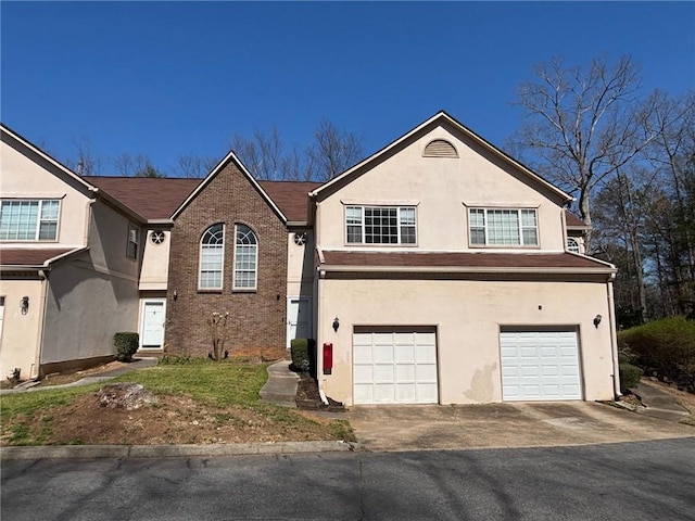 view of front facade featuring stucco siding, an attached garage, and driveway