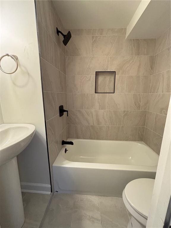 full bath with tile patterned flooring, shower / washtub combination, toilet, and baseboards