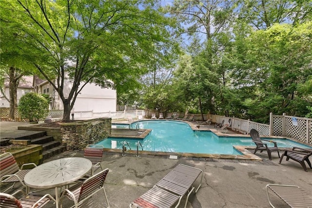 community pool featuring a patio and fence