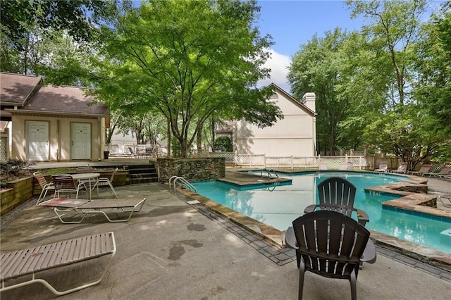 community pool featuring a patio and fence