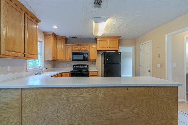 1615 Burnt Oak Way, Dacula, GA 30019 - kitchen with black appliances, light countertops, a peninsula, light tile patterned floors, and recessed lighting