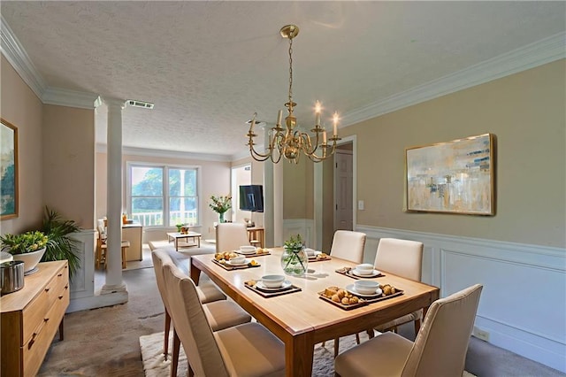 1615 Burnt Oak Way, Dacula, GA 30019 - carpeted dining area featuring a chandelier, decorative columns, crown molding, wainscoting, and a textured ceiling