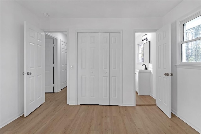 unfurnished bedroom with light hardwood / wood-style flooring and a closet