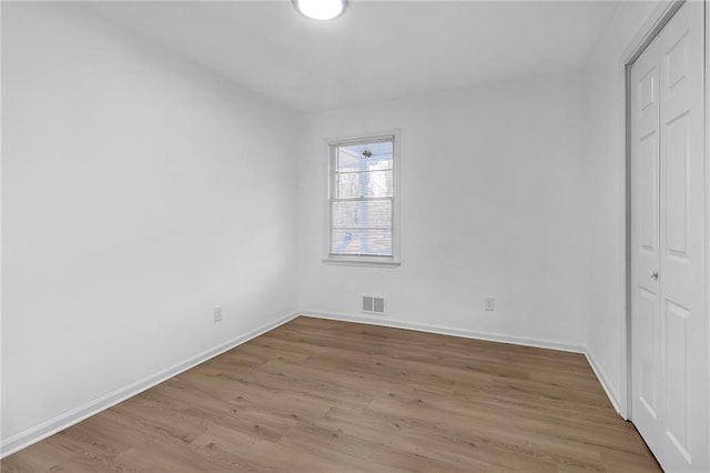 unfurnished bedroom with light wood-type flooring and a closet