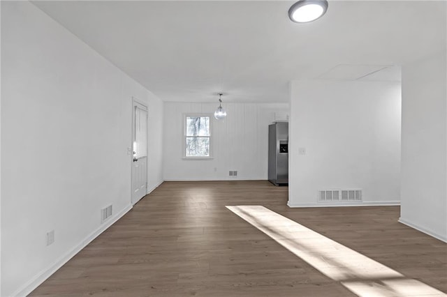 unfurnished living room with a notable chandelier and dark hardwood / wood-style flooring