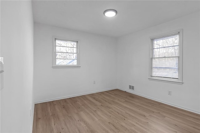 unfurnished room featuring a wealth of natural light and light hardwood / wood-style floors