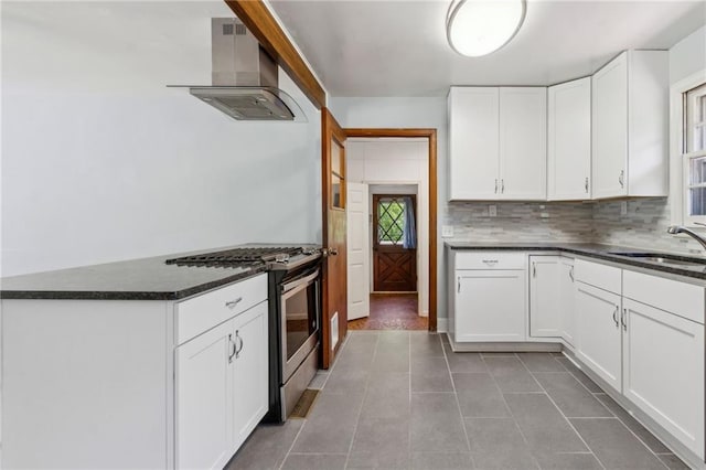 128 Mountain View Dr, Gainesville, GA 30501 - kitchen with wall chimney exhaust hood, gas stove, white cabinets, tile patterned floors, and backsplash