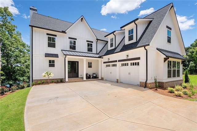 modern farmhouse style home with concrete driveway, metal roof, roof with shingles, a standing seam roof, and board and batten siding