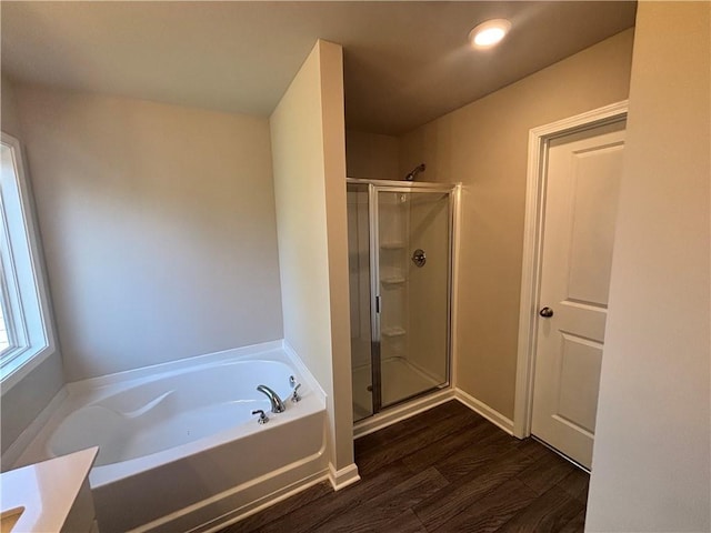 bathroom with wood-type flooring and independent shower and bath