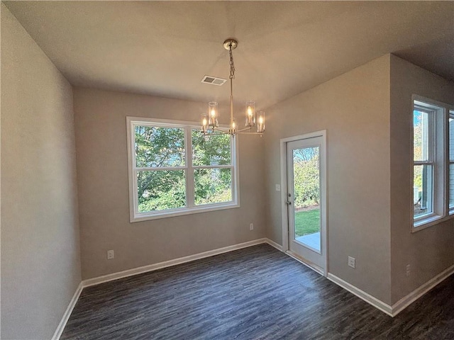 unfurnished dining area with dark hardwood / wood-style floors and a chandelier